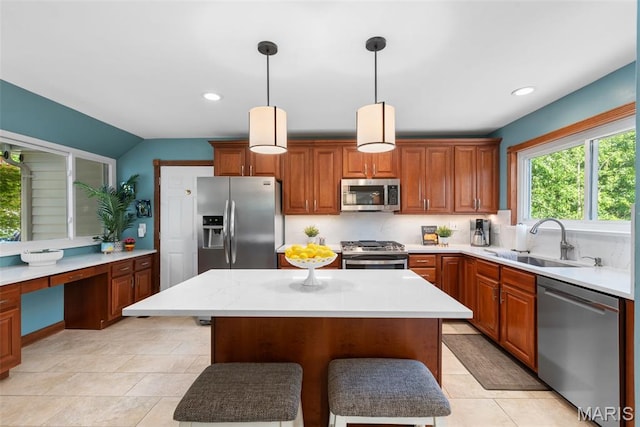 2854 Championship Blvd, Saint Louis, MO 63129 - kitchen with stainless steel appliances, a kitchen bar, a sink, light tile patterned floors, and a center island