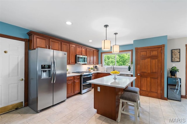 2854 Championship Blvd, Saint Louis, MO 63129 - kitchen with stainless steel appliances, light countertops, a kitchen island, decorative light fixtures, and a kitchen breakfast bar