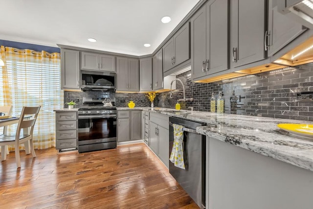 1354 Nutmeg Dr, Saint Charles, MO 63303 - kitchen with appliances with stainless steel finishes, gray cabinetry, a sink, wood-type flooring, and tasteful backsplash