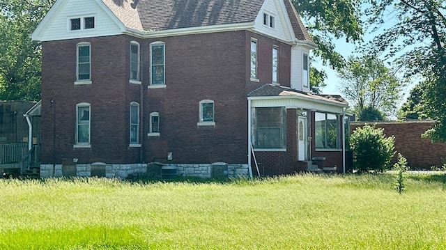 7603 State St E, St Louis, IL 62203 - view of home's exterior with entry steps, brick siding, and a lawn