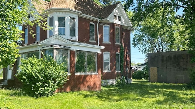 7603 State St E, St Louis, IL 62203 - view of side of home with brick siding, a lawn, and roof with shingles
