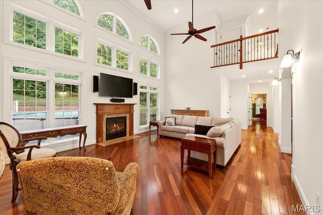 125 Park Lawn Est, Fenton, MO 63026 - living room with a high ceiling, ceiling fan, a fireplace with flush hearth, hardwood / wood-style flooring, and crown molding