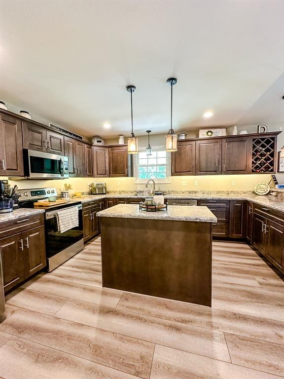 20083 Southview Dr, Carlyle, IL 62231 - kitchen with stainless steel appliances, a center island, dark brown cabinets, light wood-style flooring, and recessed lighting