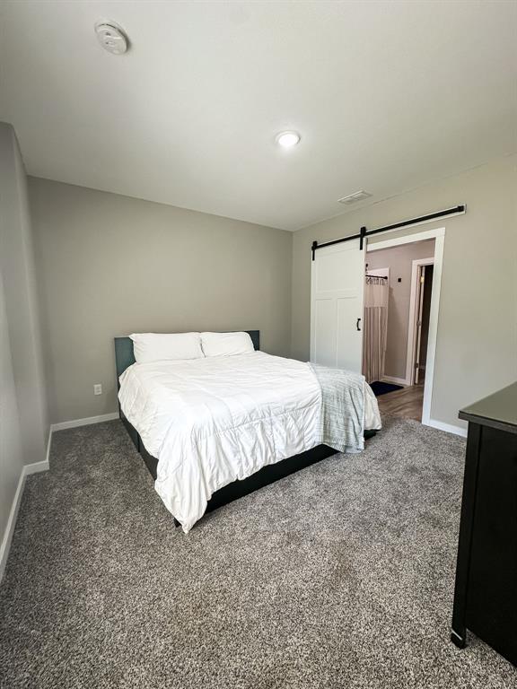 20083 Southview Dr, Carlyle, IL 62231 - carpeted bedroom featuring baseboards, a barn door, and recessed lighting