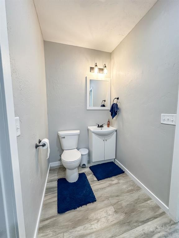 20083 Southview Dr, Carlyle, IL 62231 - bathroom with vanity, baseboards, toilet, and wood finished floors