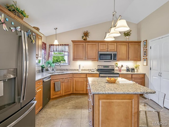 1051 Creekside Dr, Waterloo, IL 62298 - kitchen featuring stainless steel appliances, light stone counters, hanging light fixtures, a center island, and brown cabinetry