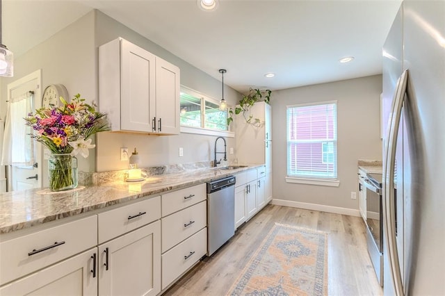 153 Mesa Dr, Waynesville, MO 65583 - kitchen featuring stainless steel appliances, a sink, white cabinetry, light wood-style floors, and light stone countertops