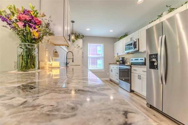153 Mesa Dr, Waynesville, MO 65583 - kitchen with stainless steel appliances, white cabinets, a sink, light stone counters, and recessed lighting