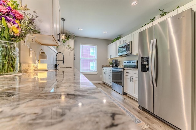 153 Mesa Dr, Waynesville, MO 65583 - kitchen with appliances with stainless steel finishes, a sink, white cabinetry, light wood-type flooring, and recessed lighting