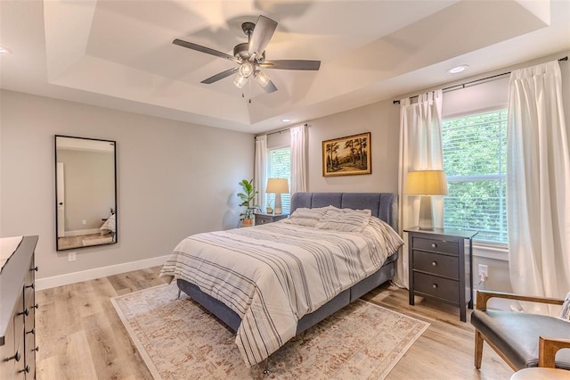153 Mesa Dr, Waynesville, MO 65583 - bedroom featuring a raised ceiling, multiple windows, light wood finished floors, recessed lighting, and baseboards