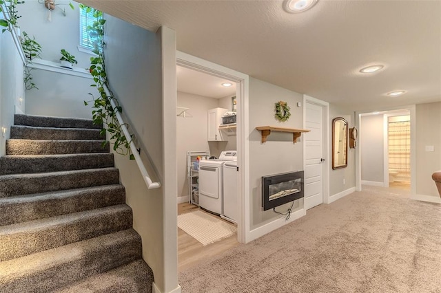 153 Mesa Dr, Waynesville, MO 65583 - stairs featuring washing machine and clothes dryer, baseboards, and a glass covered fireplace