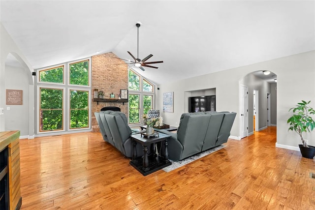 2347 Callaway Fork Rd, Defiance, MO 63341 - living room with ceiling fan, a brick fireplace, arched walkways, light wood finished floors, and high vaulted ceiling