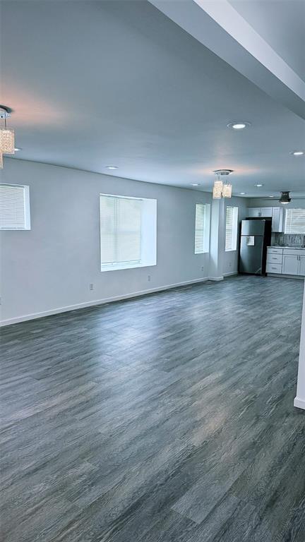 1204 Griefield Pl, Pagedale, MO 63133 - unfurnished living room featuring baseboards, dark wood finished floors, and recessed lighting
