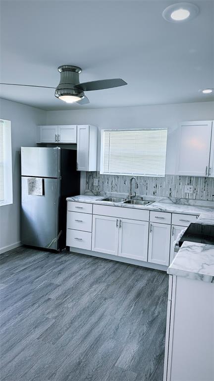 1204 Griefield Pl, Pagedale, MO 63133 - kitchen with a sink, freestanding refrigerator, white cabinetry, and decorative backsplash