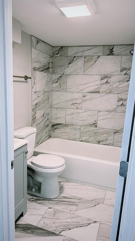 1204 Griefield Pl, Pagedale, MO 63133 - bathroom featuring vanity, marble look tiles, toilet, and shower / bath combination