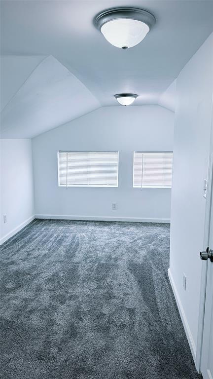 1204 Griefield Pl, Pagedale, MO 63133 - unfurnished room featuring carpet floors, vaulted ceiling, and baseboards