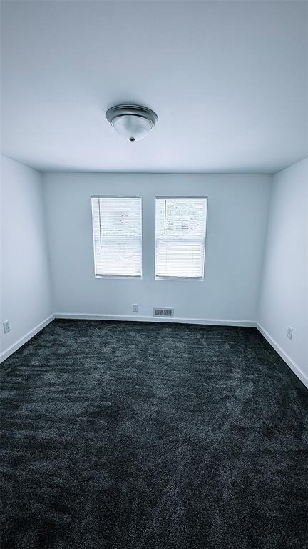 1204 Griefield Pl, Pagedale, MO 63133 - empty room with dark colored carpet and baseboards