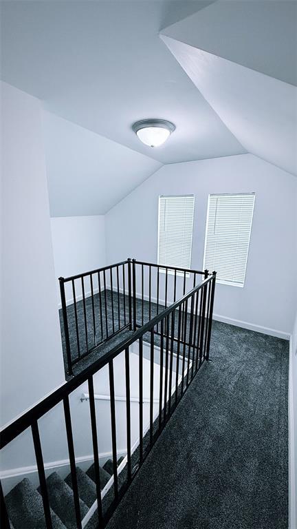 1204 Griefield Pl, Pagedale, MO 63133 - corridor with an upstairs landing, vaulted ceiling, and baseboards