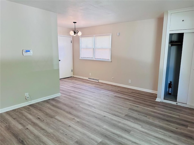 9715 Millburn Dr, Saint Louis, MO 63136 - unfurnished living room featuring wood finished floors, baseboards, and a chandelier