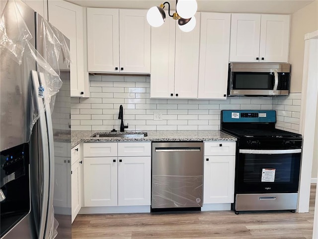 9715 Millburn Dr, Saint Louis, MO 63136 - kitchen with appliances with stainless steel finishes, a sink, and white cabinets