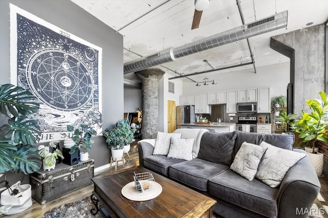 2020 Washington Ave Unit 210, Saint Louis, MO 63103 - living room featuring wood finished floors, a towering ceiling, and decorative columns