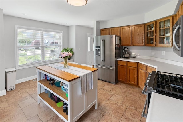 21 Sunny Dale Ct, Glen Carbon, IL 62034 - kitchen with appliances with stainless steel finishes, brown cabinetry, glass insert cabinets, open shelves, and baseboards
