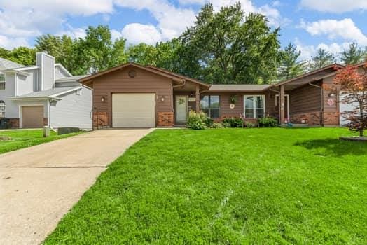 352 Della Dr, Saint Peters, MO 63376 - view of front facade with driveway, a front lawn, a garage, and brick siding