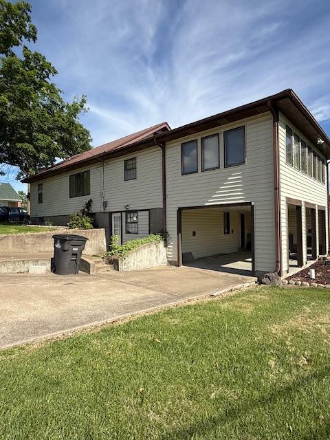 133 S Walnut St, Perryville, MO 63775 - back of house featuring driveway, a yard, and a garage