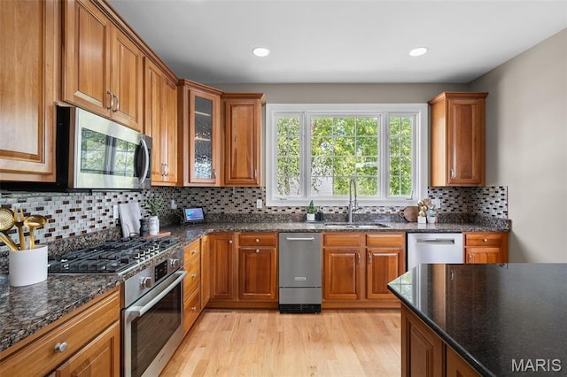 4516 Austin Point Ct, Saint Charles, MO 63304 - kitchen featuring appliances with stainless steel finishes, brown cabinetry, light wood-style flooring, tasteful backsplash, and recessed lighting