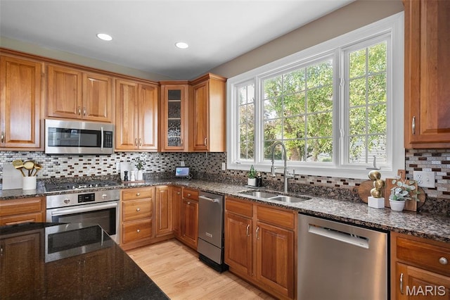 4516 Austin Point Ct, Saint Charles, MO 63304 - kitchen with stainless steel appliances, brown cabinetry, dark stone counters, and recessed lighting
