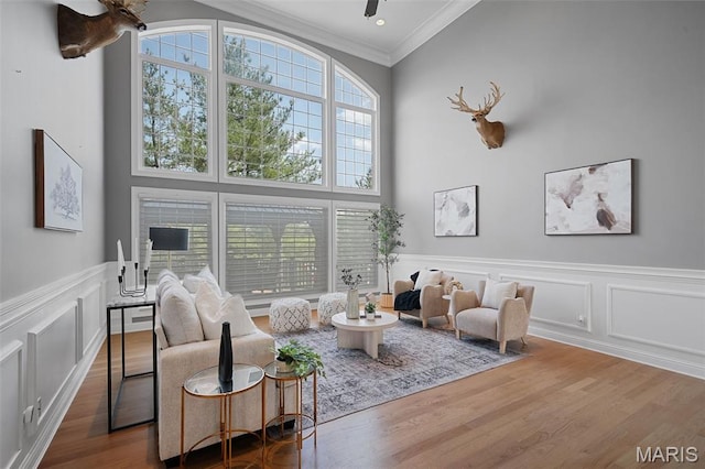 4516 Austin Point Ct, Saint Charles, MO 63304 - living area with wood finished floors, crown molding, a ceiling fan, a high ceiling, and a decorative wall