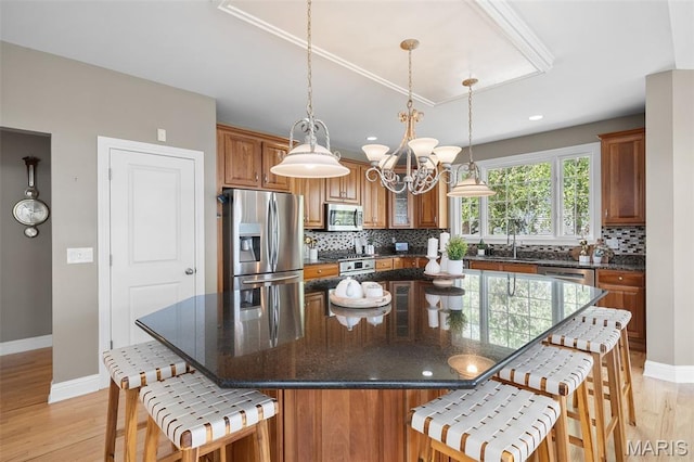 4516 Austin Point Ct, Saint Charles, MO 63304 - kitchen with stainless steel appliances, a breakfast bar, brown cabinetry, backsplash, and recessed lighting