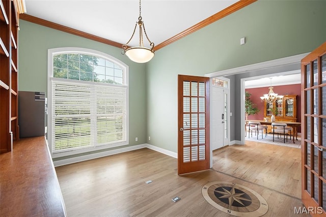 4516 Austin Point Ct, Saint Charles, MO 63304 - unfurnished dining area featuring a chandelier, wood finished floors, crown molding, and french doors