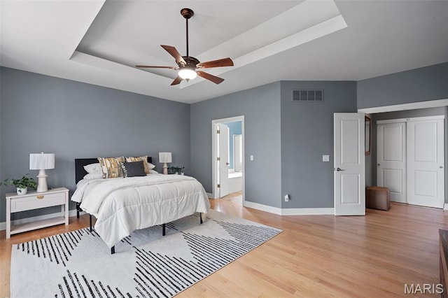 4516 Austin Point Ct, Saint Charles, MO 63304 - bedroom with a tray ceiling, light wood-type flooring, a ceiling fan, and ensuite bath