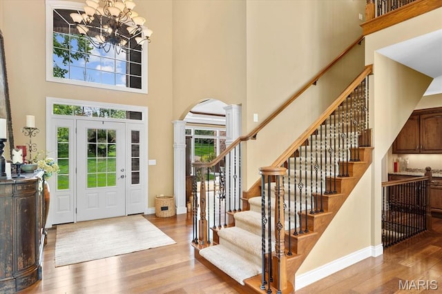 4516 Levis Ln, Godfrey, IL 62035 - foyer featuring a towering ceiling, arched walkways, wood finished floors, decorative columns, and a chandelier