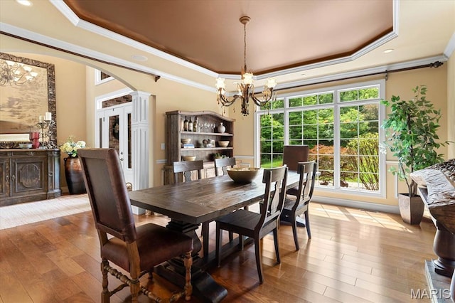 4516 Levis Ln, Godfrey, IL 62035 - dining room featuring a tray ceiling, a chandelier, crown molding, arched walkways, and hardwood / wood-style floors
