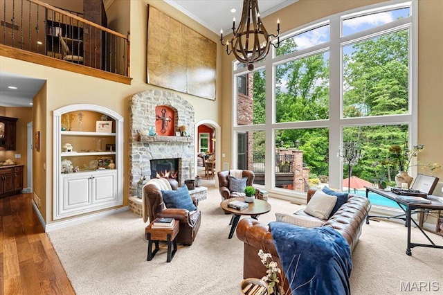 4516 Levis Ln, Godfrey, IL 62035 - living room with a high ceiling, healthy amount of natural light, a chandelier, crown molding, and a stone fireplace