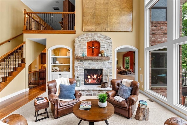 4516 Levis Ln, Godfrey, IL 62035 - living area featuring a towering ceiling, a stone fireplace, stairway, wood finished floors, and built in features