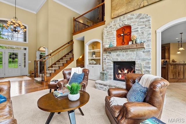 4516 Levis Ln, Godfrey, IL 62035 - living area featuring arched walkways, stairs, crown molding, a chandelier, and a stone fireplace