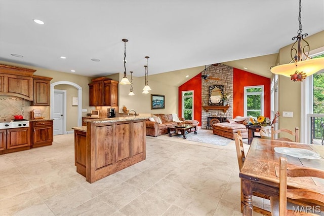 4516 Levis Ln, Godfrey, IL 62035 - kitchen with stovetop, arched walkways, open floor plan, brown cabinets, and pendant lighting