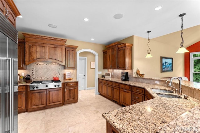 4516 Levis Ln, Godfrey, IL 62035 - kitchen with a sink, tasteful backsplash, appliances with stainless steel finishes, arched walkways, and a peninsula