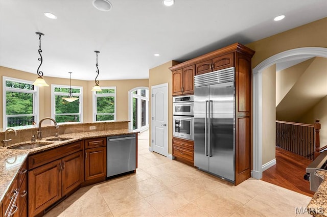 4516 Levis Ln, Godfrey, IL 62035 - kitchen featuring appliances with stainless steel finishes, a sink, light stone counters, hanging light fixtures, and recessed lighting