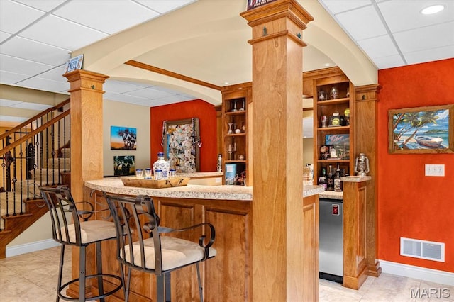 4516 Levis Ln, Godfrey, IL 62035 - indoor wet bar with ornate columns, stairway, baseboards, and arched walkways