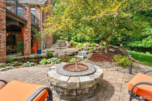 4516 Levis Ln, Godfrey, IL 62035 - view of patio / terrace featuring a fire pit, a balcony, and a garden pond
