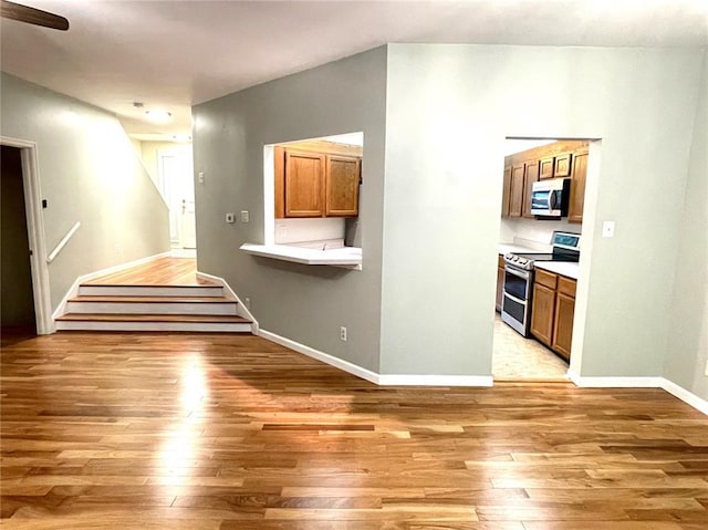 13613 Mason Oaks Ln Unit 3, Saint Louis, MO 63131 - interior space featuring stainless steel appliances, light wood finished floors, brown cabinets, and baseboards
