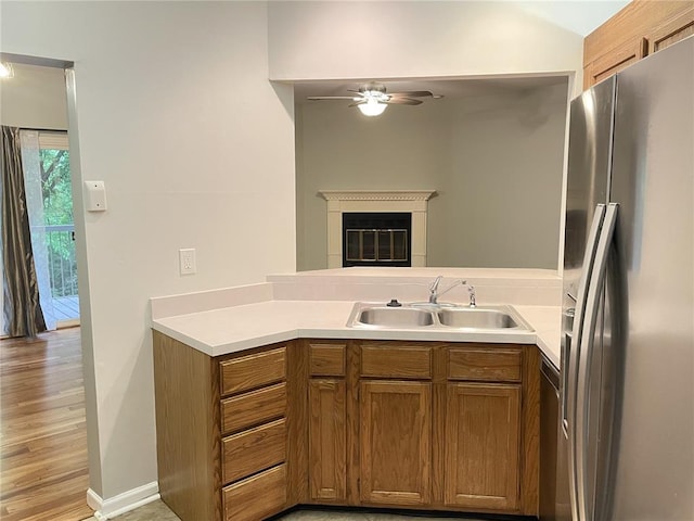 13613 Mason Oaks Ln Unit 3, Saint Louis, MO 63131 - kitchen featuring stainless steel fridge, a ceiling fan, a sink, brown cabinets, and a peninsula