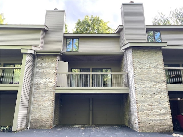 13613 Mason Oaks Ln Unit 3, Saint Louis, MO 63131 - rear view of property with a balcony, a chimney, and brick siding
