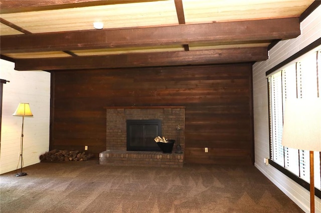 11 Glen Hollow Rd, Glen Carbon, IL 62034 - unfurnished living room with wooden walls, beam ceiling, carpet floors, and a fireplace
