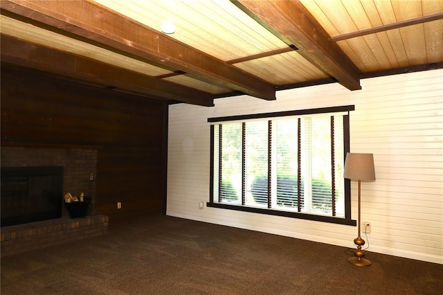 11 Glen Hollow Rd, Glen Carbon, IL 62034 - unfurnished living room with wood walls, wooden ceiling with exposed beams, dark colored carpet, and a brick fireplace
