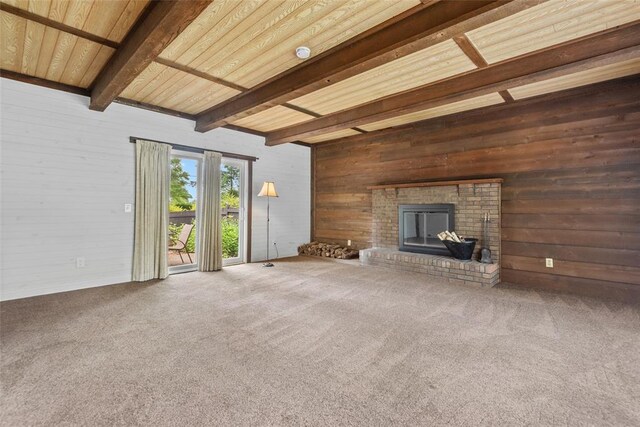 11 Glen Hollow Rd, Glen Carbon, IL 62034 - unfurnished living room with beam ceiling, wooden walls, a brick fireplace, and carpet flooring